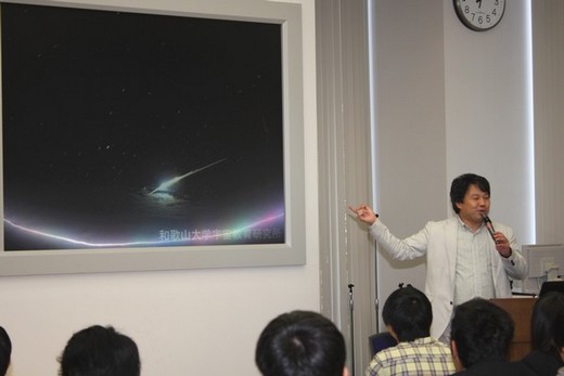 「はやぶさ」の写真を見せながら宇宙教育研究所の紹介をする秋山所長